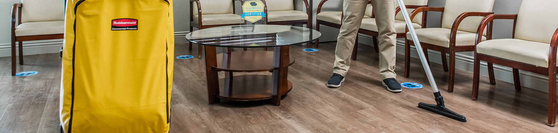 ServiceMaster Clean professional performing a hardwood floor cleaning service in a commercial lobby