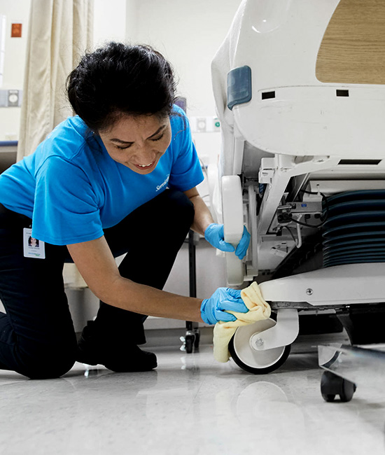 women wiping hospital bed
