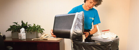 Woman emptying trash in trashcan