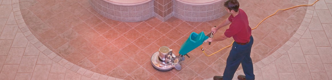man using a floor waxer on tile floors